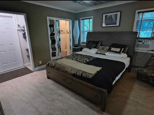 a bed sitting in a room next to a flat screen tv