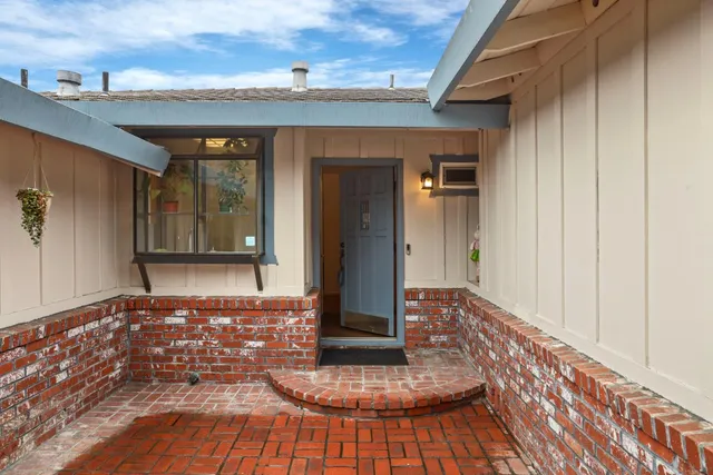 a view of a hallway with wooden floor and a bathroom