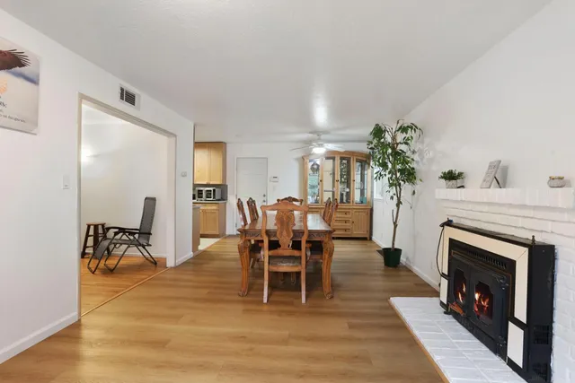 a dining room with furniture a fireplace and wooden floor