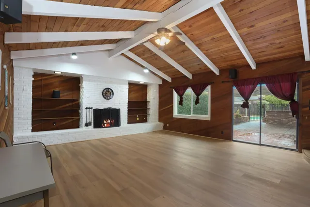 a view of an empty room with a fireplace and a window