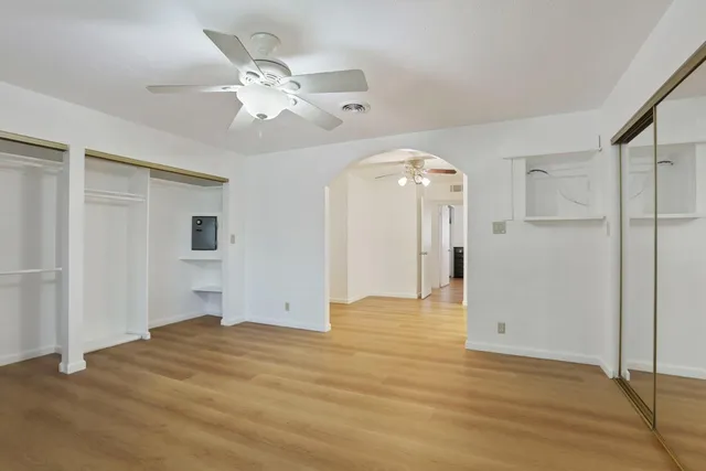 a view of a livingroom with a chandelier fan and wooden floor