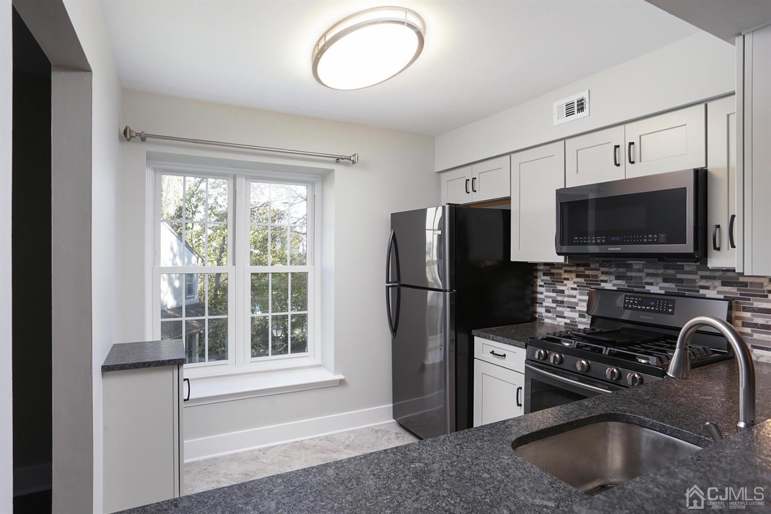 205 Commons Way Drive, Unit 5 East Brunswick, NJ 08816 - Photo 11 of 22 a kitchen with stainless steel appliances a microwave a sink and a refrigerator