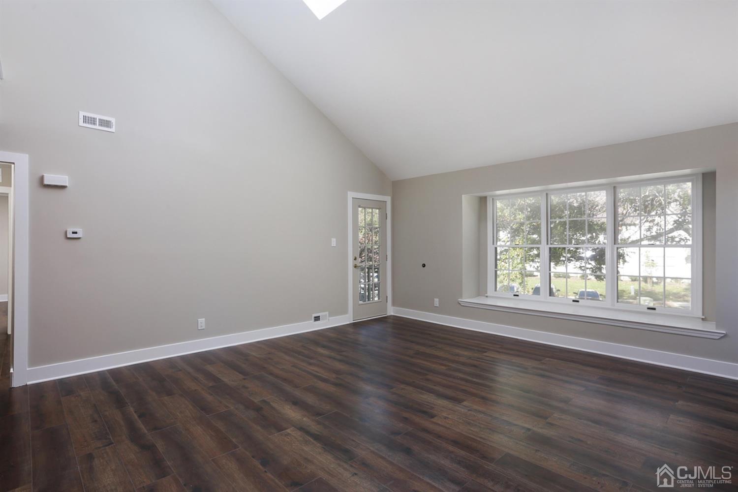 205 Commons Way Drive, Unit 5 East Brunswick, NJ 08816 - Photo 5 of 22 an empty room with wooden floor and windows