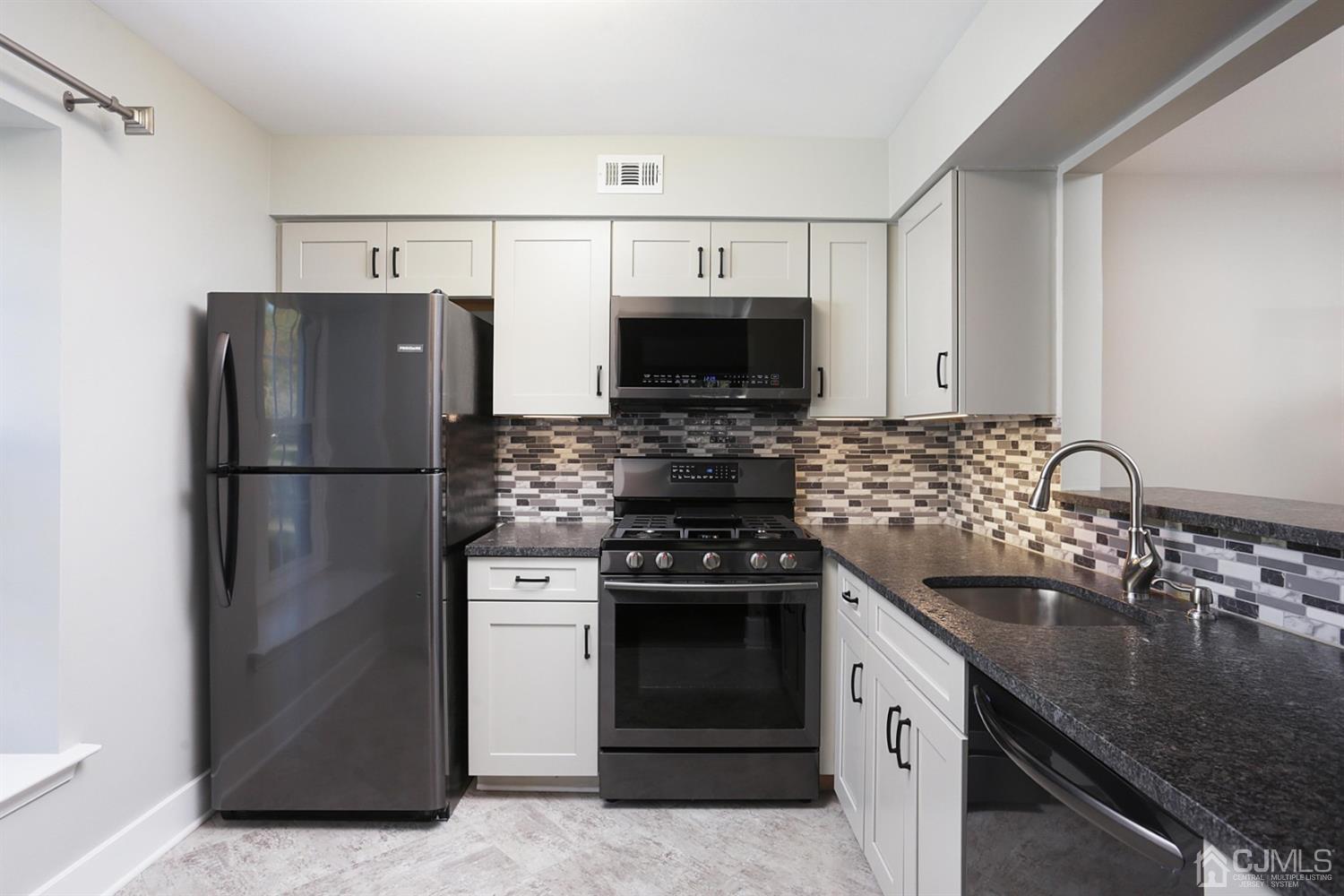 205 Commons Way Drive, Unit 5 East Brunswick, NJ 08816 - Photo 9 of 22 a kitchen with stainless steel appliances granite countertop a refrigerator stove and sink
