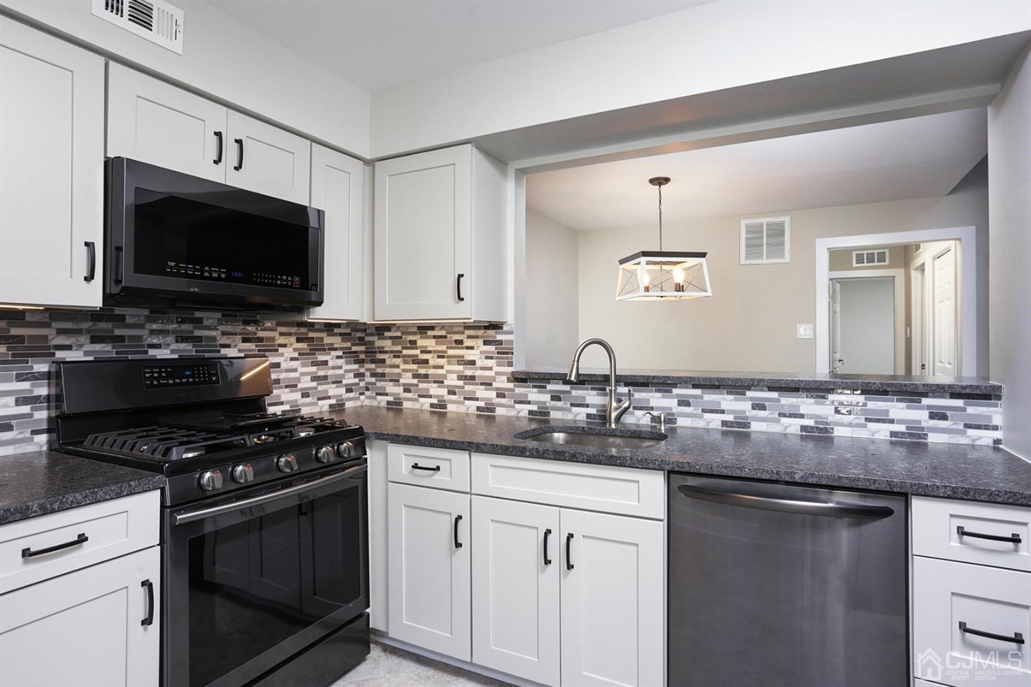 205 Commons Way Drive, Unit 5 East Brunswick, NJ 08816 - Photo 10 of 22 a kitchen with granite countertop a sink and a stove top oven