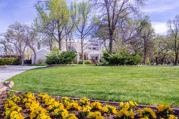a front view of a house with a big yard and fountain