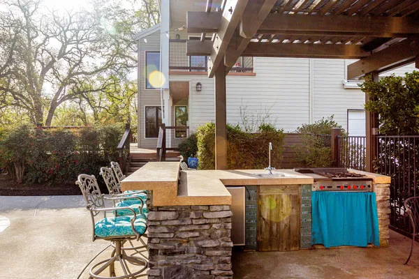 a view of a field with an ocean and trees in the background