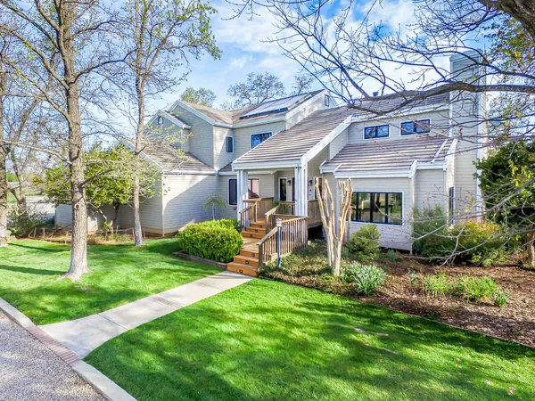 a front view of a house with swimming pool and garden