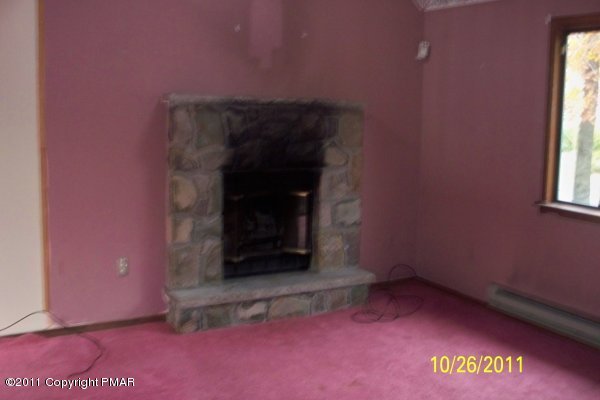 701 Edgewood Road Tobyhanna, PA 18466 - Photo 2 of 8 a view of an empty room with a fireplace and a window