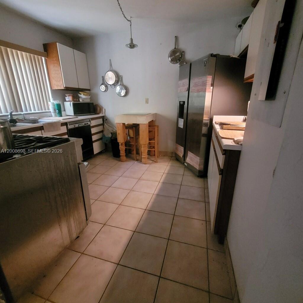 8339 Southwest 112th Street Miami, FL 33156 - Photo 20 of 30 a kitchen with granite countertop a refrigerator a stove a sink a washer and dryer
