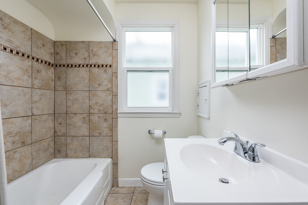 1111 Jones Avenue Racine, WI 53402 - Photo 15 of 27 a bathroom with a bathtub a sink a toilet and a mirror
