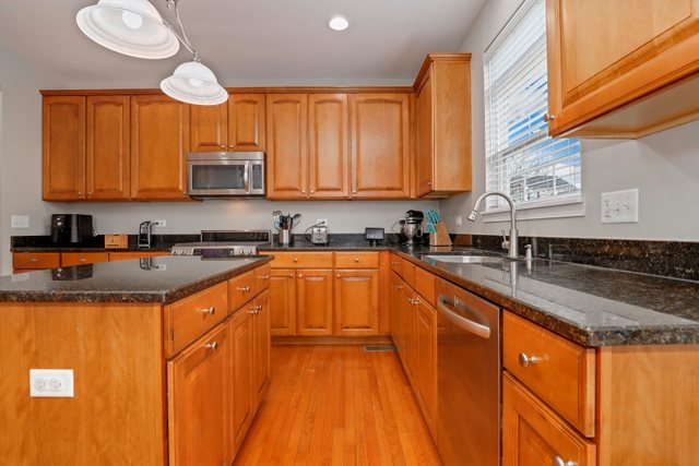 5961 Chatham Drive Hoffman Estates, IL 60192 - Photo 11 of 39 a kitchen with stainless steel appliances granite countertop a sink a stove and a refrigerator