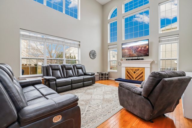5961 Chatham Drive Hoffman Estates, IL 60192 - Photo 16 of 39 a living room with furniture a flat screen tv and a fireplace