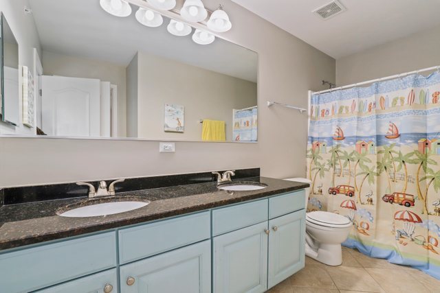 5961 Chatham Drive Hoffman Estates, IL 60192 - Photo 26 of 39 a bathroom with a granite countertop sink a toilet and a shower