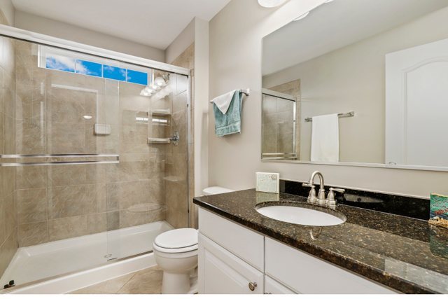 5961 Chatham Drive Hoffman Estates, IL 60192 - Photo 31 of 39 a bathroom with a granite countertop sink toilet and shower