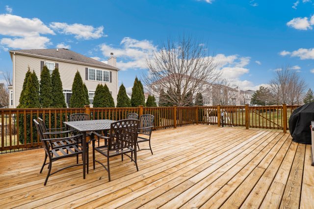 5961 Chatham Drive Hoffman Estates, IL 60192 - Photo 35 of 39 a view of a roof deck with table and chairs a barbeque with wooden floor and fence