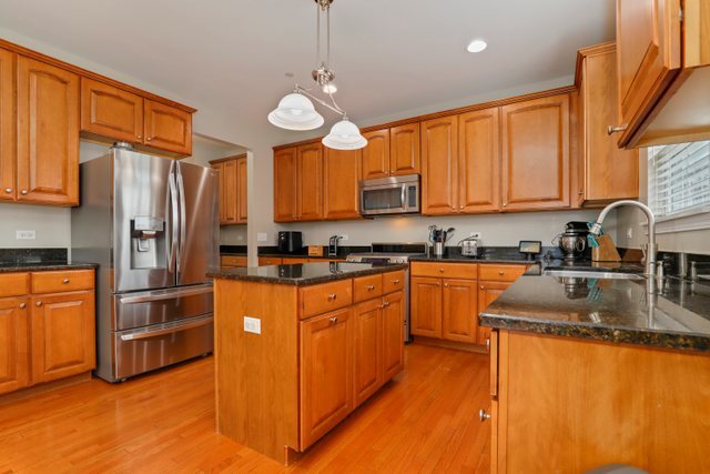 5961 Chatham Drive Hoffman Estates, IL 60192 - Photo 8 of 39 a kitchen with stainless steel appliances granite countertop a sink a stove and a refrigerator