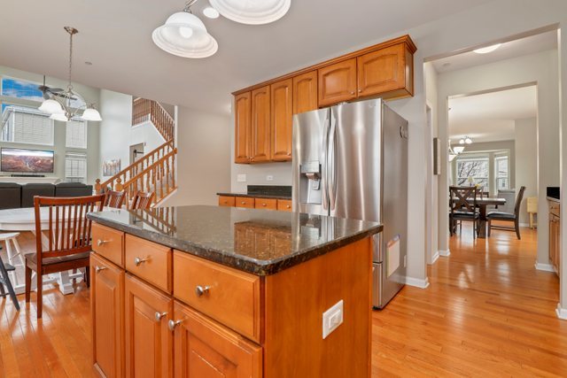 5961 Chatham Drive Hoffman Estates, IL 60192 - Photo 10 of 39 a kitchen with stainless steel appliances granite countertop a refrigerator a stove and a wooden cabinets with wooden floor