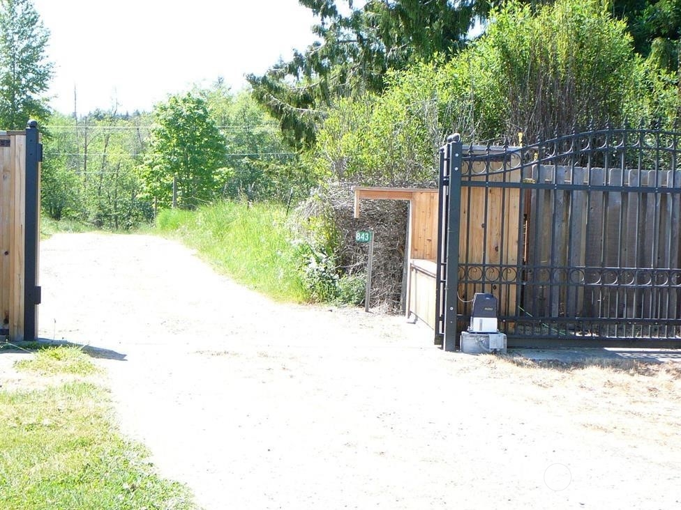 843 Sherburne Road Sequim, WA 98382 - Photo 4 of 40 a view of backyard with wooden fence and trees