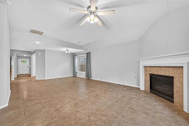 a view of empty room with fan and fireplace