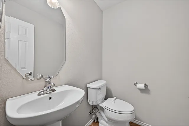 a bathroom with a sink a toilet and a mirror