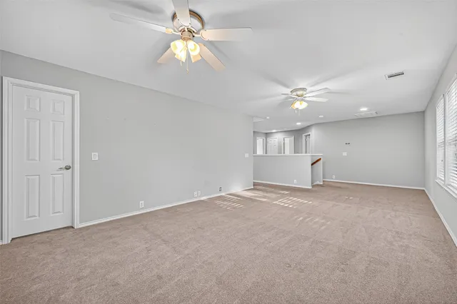 a view of empty room with a ceiling fan and window
