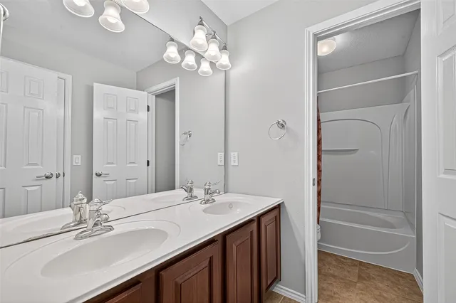 a bathroom with a sink double vanity granite tub and a mirror