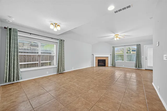 a view of an empty room with a fireplace and a window