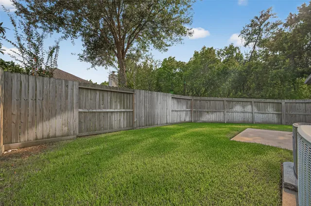 a view of a backyard with a fence and trees