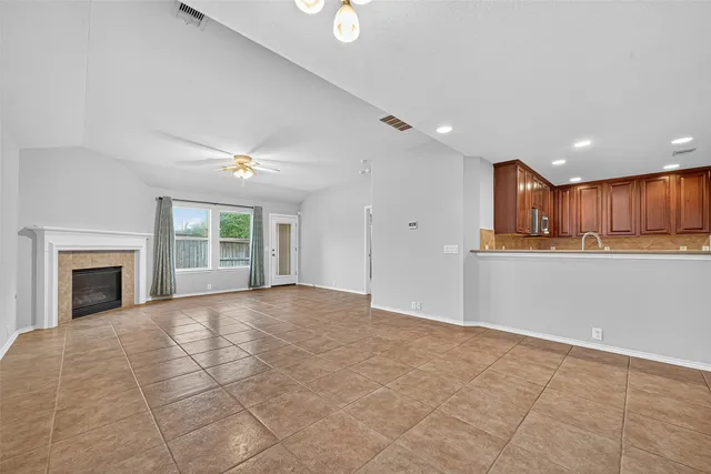 a view of a livingroom with an empty space and a kitchen