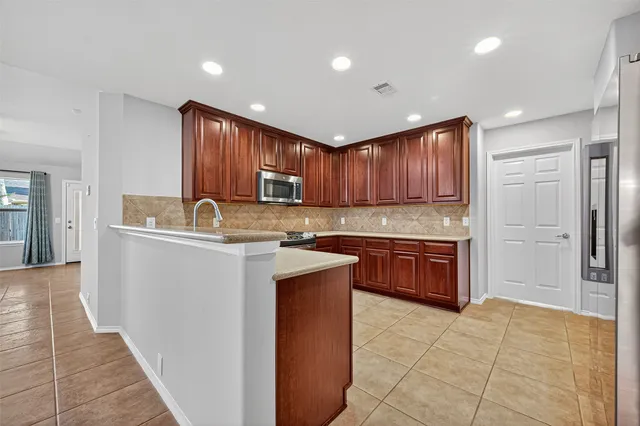 a kitchen with a refrigerator sink and cabinets