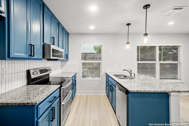 a kitchen with stainless steel appliances granite countertop a sink stove and cabinets