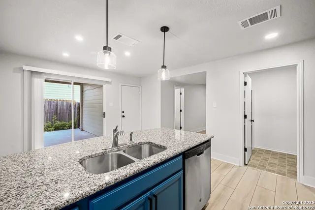 a kitchen with granite countertop a sink and a wooden floor