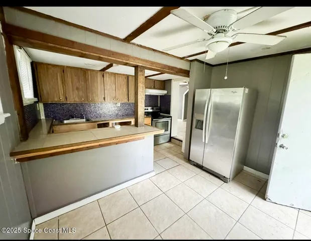 a kitchen with stainless steel appliances a refrigerator and microwave