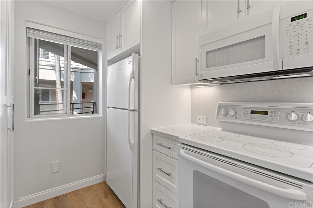 2243 Martin, Unit 314 Irvine, CA 92612 - Photo 8 of 75 a white refrigerator freezer and a stove sitting inside of a kitchen