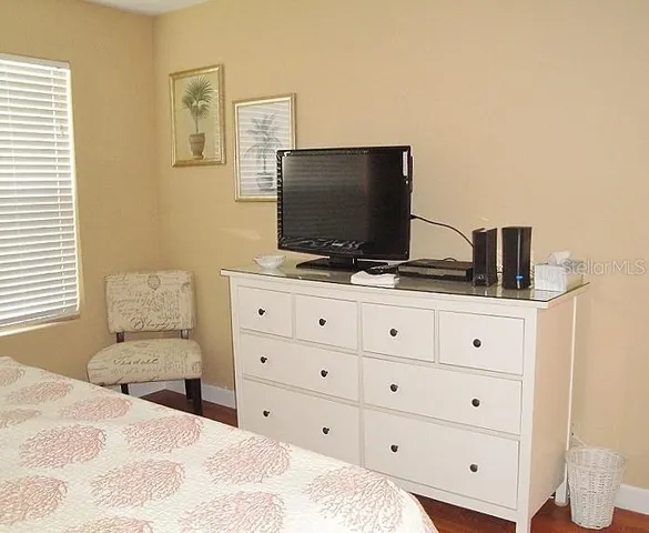 a bedroom with a bed and a flat screen tv