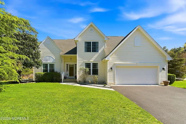 a front view of yellow house with a yard and garage