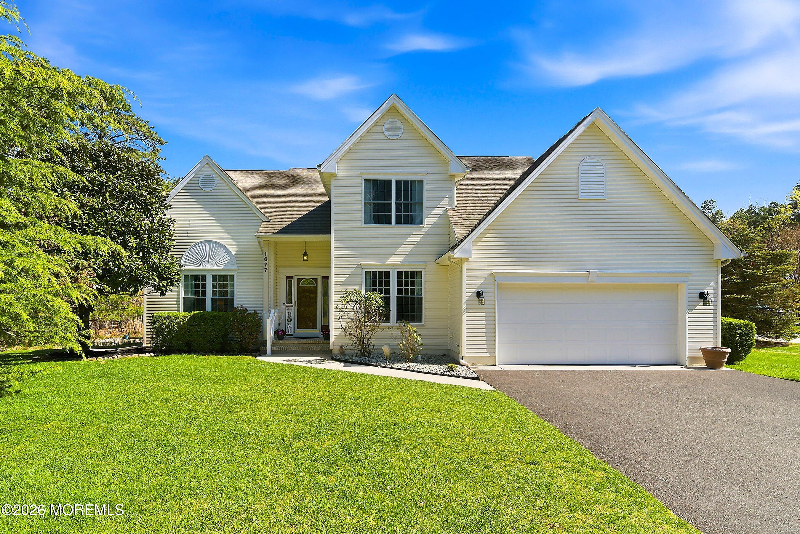 1677 Joffre Road Forked River, NJ 08731 - Photo 1 of 35 a front view of yellow house with a yard and garage
