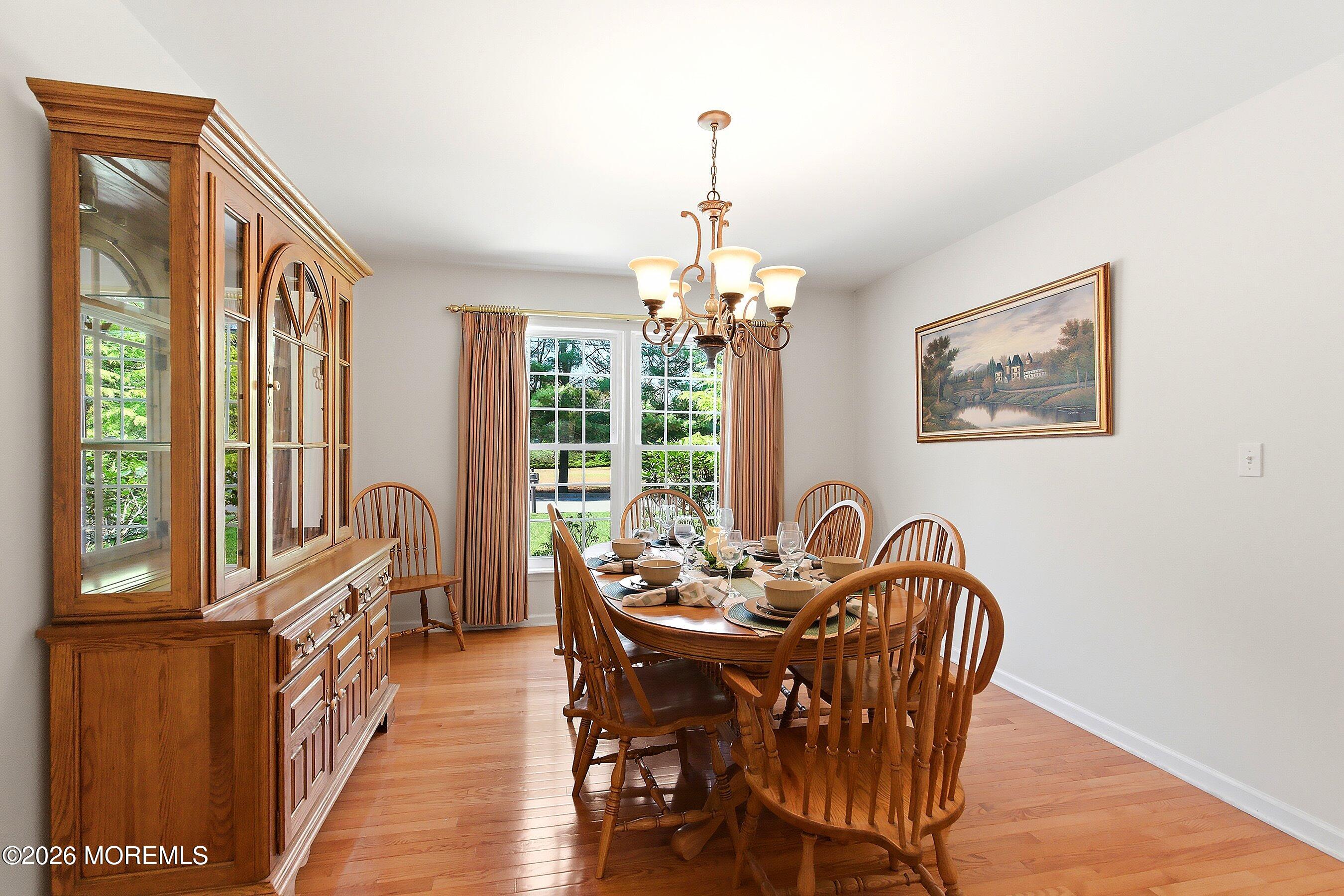 1677 Joffre Road Forked River, NJ 08731 - Photo 13 of 35 a dining room with furniture a chandelier and wooden floor