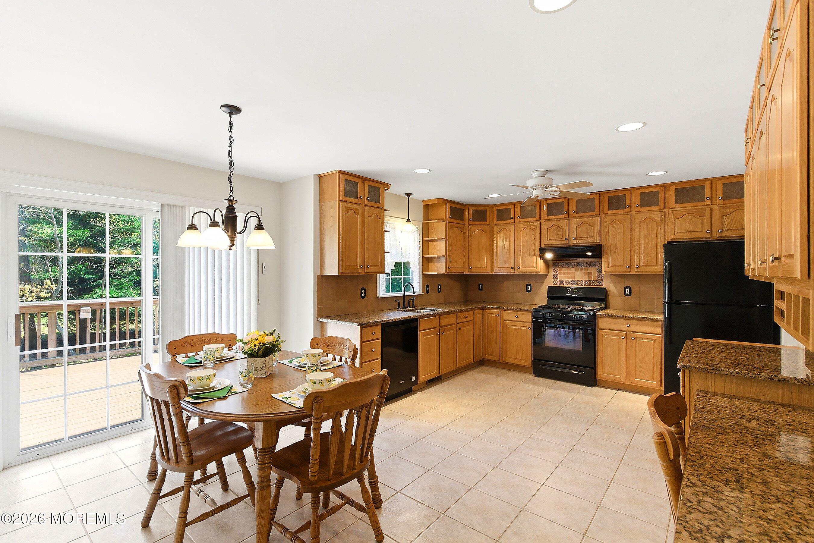 1677 Joffre Road Forked River, NJ 08731 - Photo 8 of 35 a kitchen with stainless steel appliances kitchen island granite countertop a refrigerator a stove a sink dishwasher with a dining table and chairs