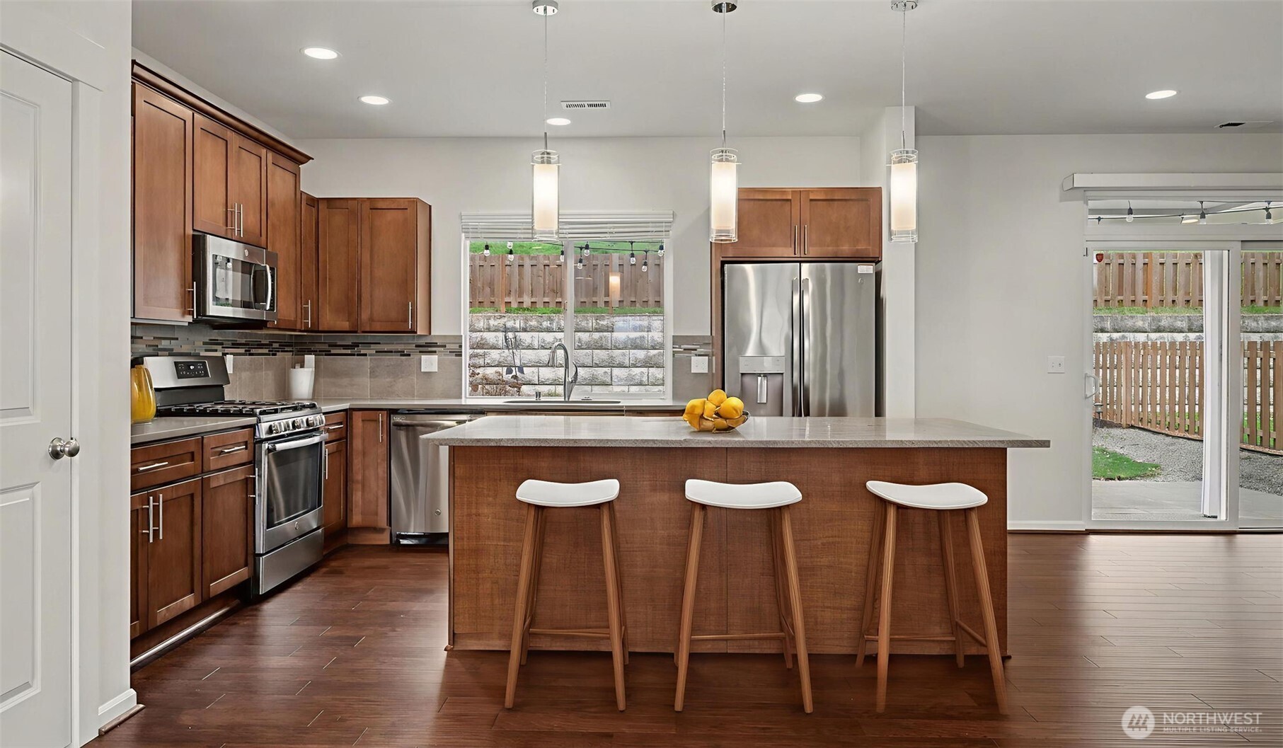 20024 90th Place South Kent, WA 98031 - Photo 3 of 28 a kitchen with stainless steel appliances kitchen island granite countertop a stove a sink and a refrigerator
