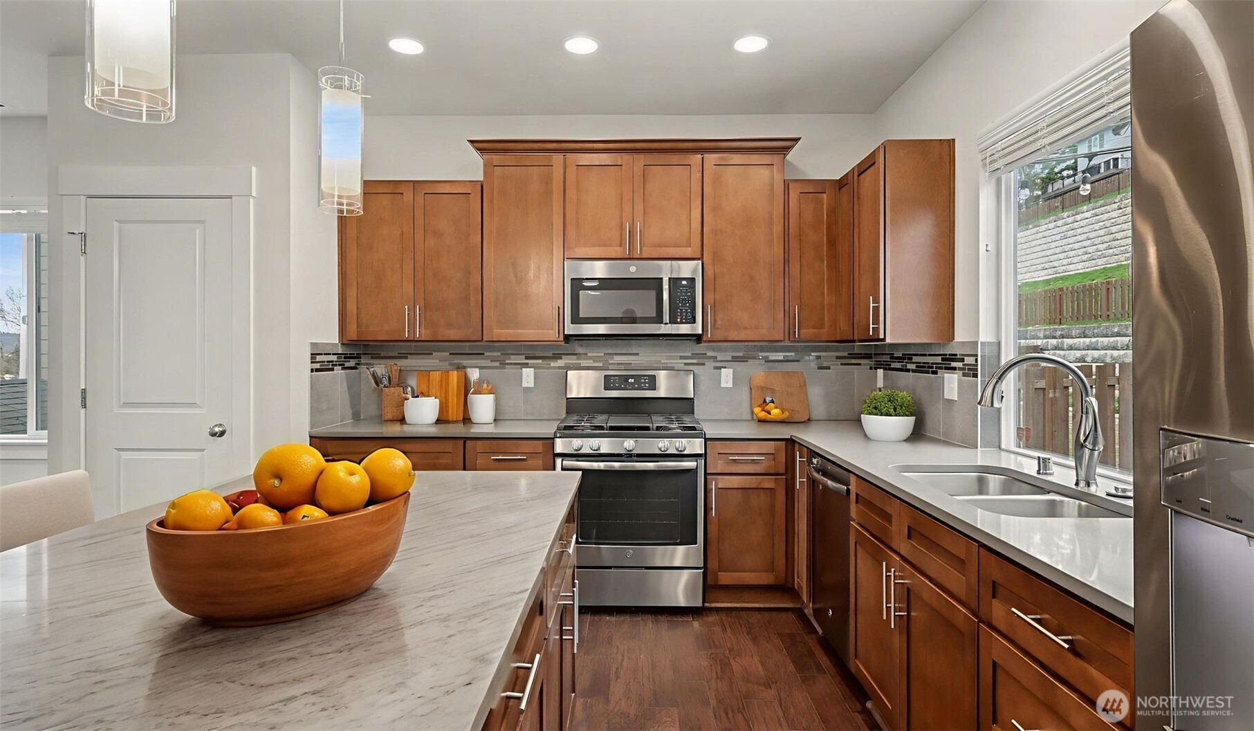 20024 90th Place South Kent, WA 98031 - Photo 5 of 28 a kitchen with stainless steel appliances granite countertop a stove top oven a sink dishwasher and wooden cabinets with wooden floor