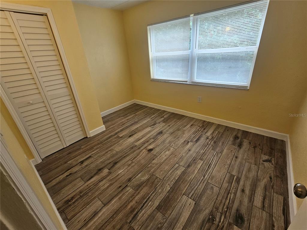 2045 Alpine Road, Unit 3 Clearwater, FL 33755 - Photo 15 of 18 a view of an empty room with wooden floor and a window