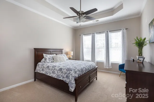 a bed sitting in a spacious bedroom next to a window