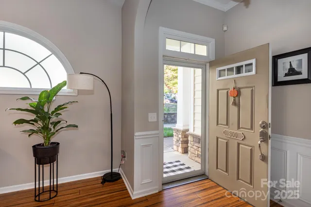 a view of a hallway with wooden floor and a potted plant