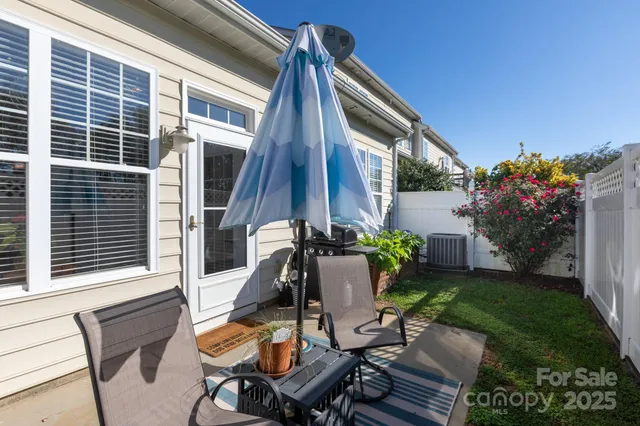 a view of backyard with a table and chairs and potted plants