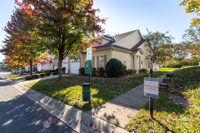 a view of a house with a yard patio and a tree
