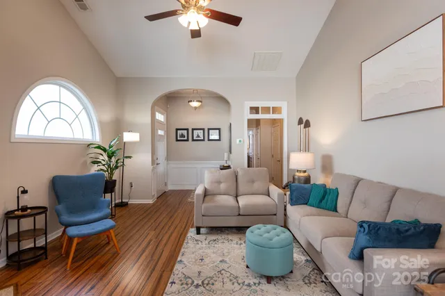 a living room with furniture a chandelier and a window