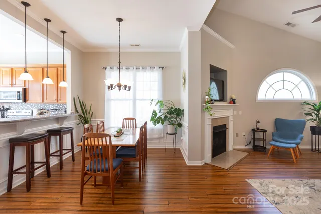 a dining room with furniture a chandelier and wooden floor