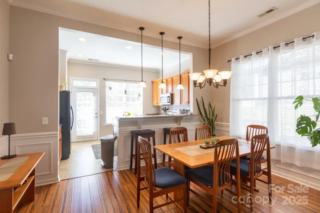 a dining room with furniture a chandelier and wooden floor